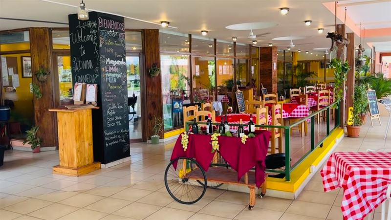 Comedor real de La Divina Commedia — carrito de vinos y mesas con mantel a cuadros