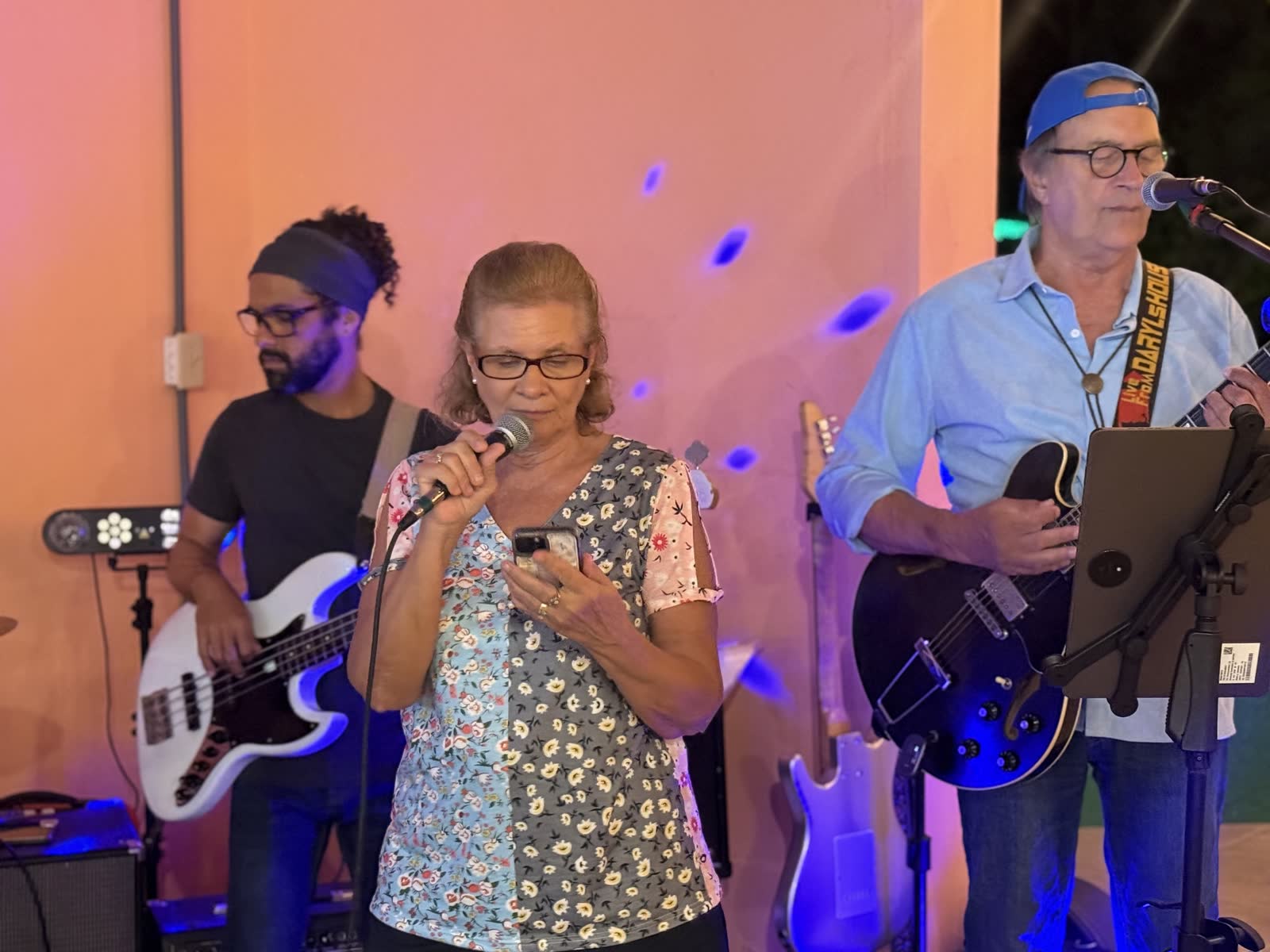 Foto real de la banda y una invitada cantando karaoke en La Divina Commedia Coronado