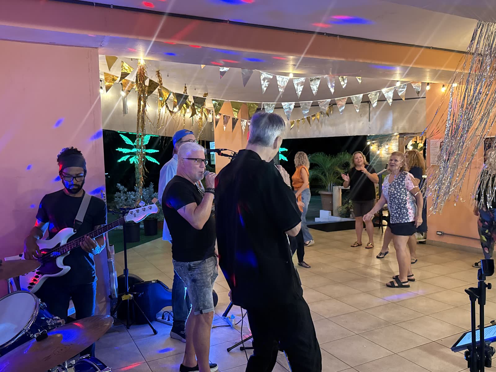 Foto real de los invitados bailando en la noche de karaoke en La Divina Commedia Coronado