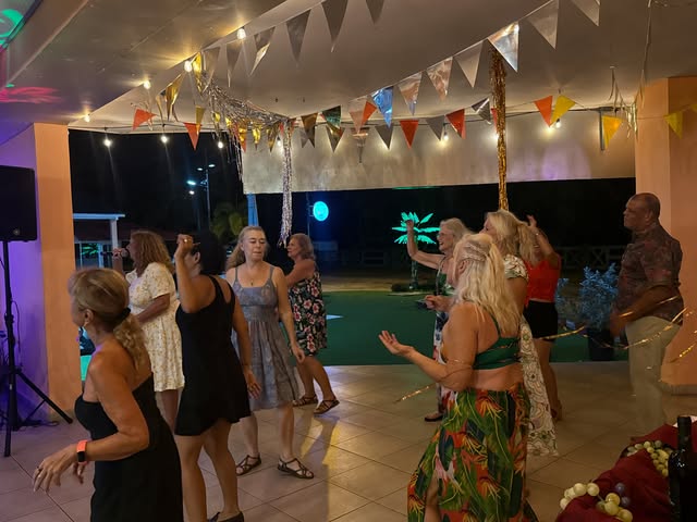 Real photo of guests dancing on the terrace at La Divina Commedia Coronado, under bunting and colored lights