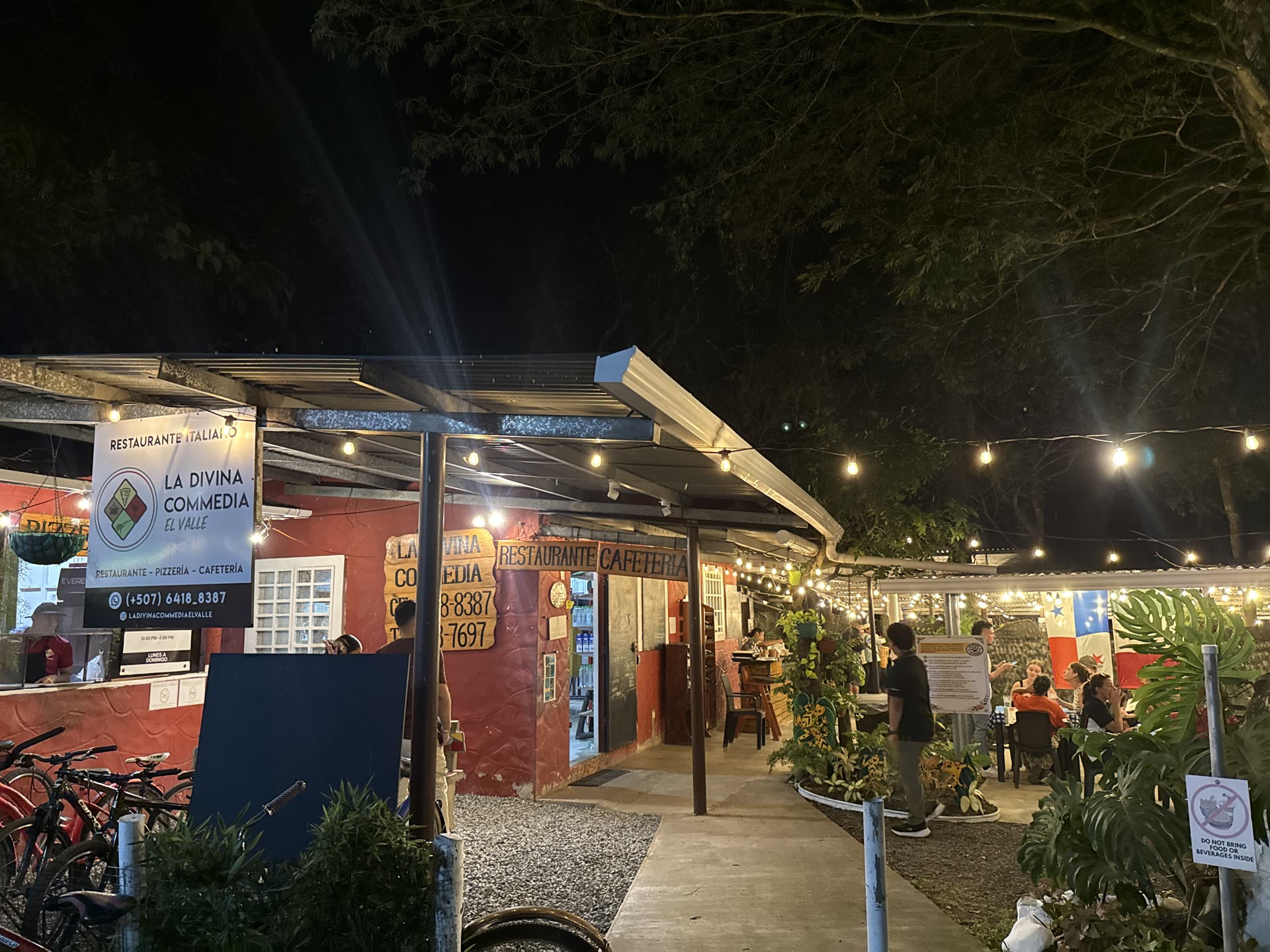 Real photo of La Divina Commedia El Valle's facade, at night